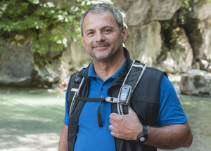 Wanderer mit Mobiler Rufhilfe am Rucksack