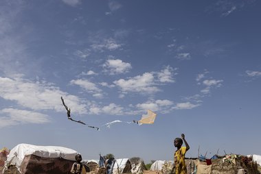 Ein Kind aus dem Sudan spielt in einem Flüchtlingscamp mit seinem Drachen.