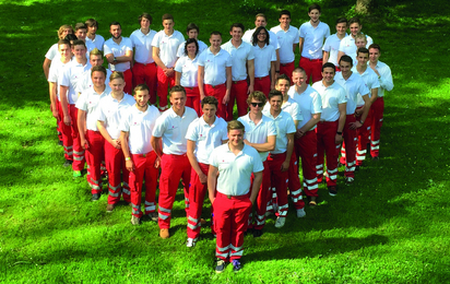 Rotkreuz-Mitarbeiter sind in Uniform als Herz positioniert