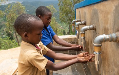 Zwei Buben aus Ruanda waschen sich die Hände