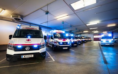 Einsatzfahrzeuge stehen mit Blaulicht in der Garage