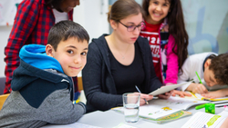 Kinder beim lernen mit Betreuerin