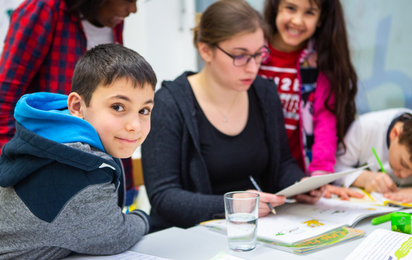 Kinder beim lernen mit Betreuerin