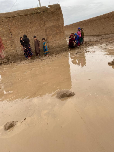 Kinder in Afghanistan stehen am Rand, um sich vor dem Hochwasser zu schützen