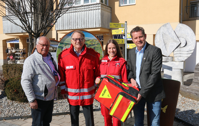 Gruppenfoto mit 4 Personen während der Übergabe eines Rucksacks