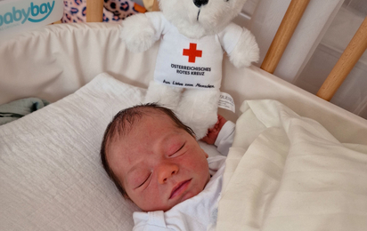 Der kleine Johannes liegt im Babybett des Krankenhauses.