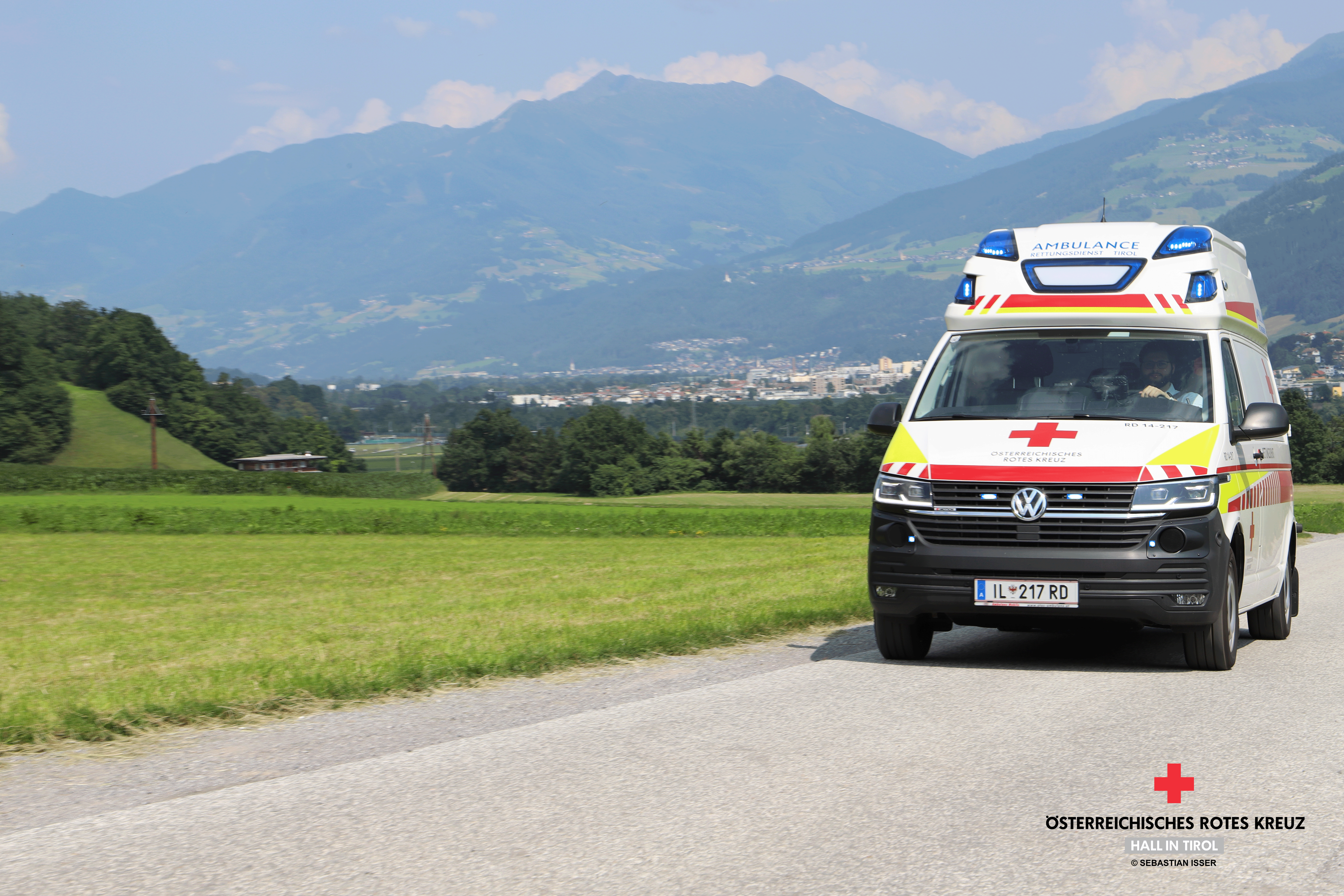 RTW VW auf T6 Basis auf Einsatzfahrt auf einer Straße im Grünen